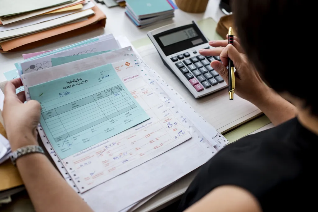 Bioconstruir | Asian Woman Working Through Paperwork